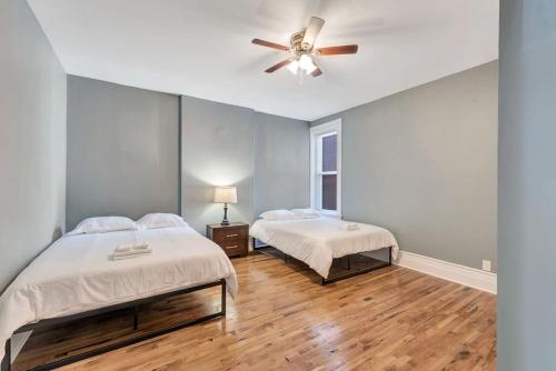 a bedroom with two beds and a ceiling fan at Central St Louis apartment 1W in Soulard