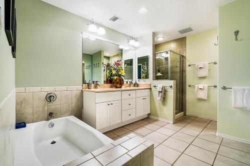 La salle de bains spacieuse est pourvue d'une grande baignoire et d'une douche. dans l'établissement Colony Villas at Waikoloa Beach Resort #204, à Waikoloa