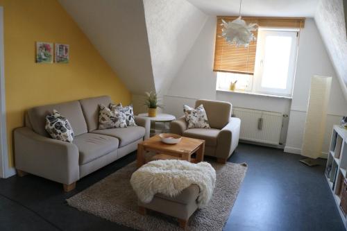 a living room with two couches and a table at Ferienwohnung Mandelblüte in Schotten