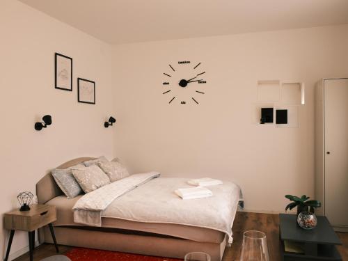 1 dormitorio con 1 cama y reloj en la pared en Studio apartmani Venium, en Križevci