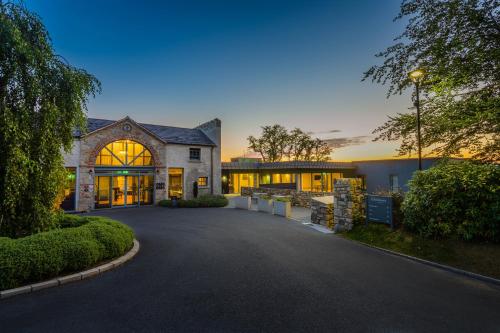 une grande maison avec une allée en face de celle-ci dans l'établissement Killeavy Castle Estate, à Meigh