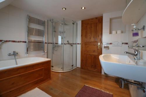 La salle de bains est pourvue d'une baignoire, d'une douche et d'un lavabo. dans l'établissement Ferienhaus Apfelblüte, à Schotten