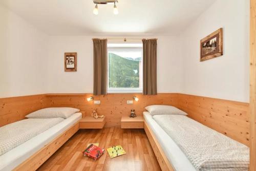 2 camas en una habitación con ventana en Jaiterhof Apartment Reinhold Messner, en Villnoss