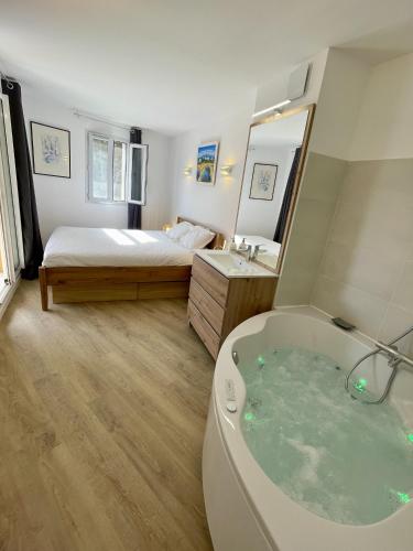 a bathroom with a bath tub and a bed at PINEDE PLAGE 5 personnes climatisation vue mer et parc in Hyères