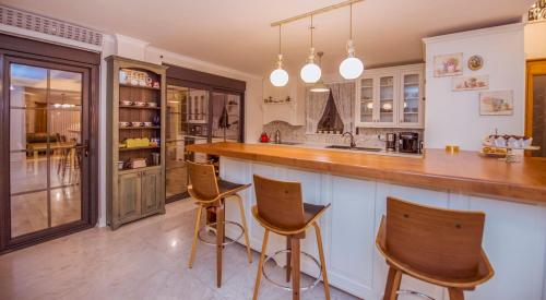 a kitchen with three bar stools and a counter at Villa TN - Fethiye in Fethiye
