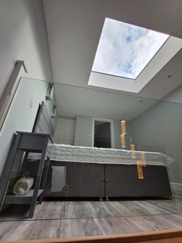 a loft bed in a room with a large window at Livestay Luxury Studio in N22 London in London