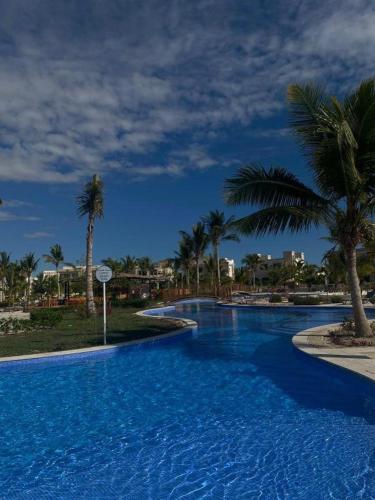 a large swimming pool with palm trees in a resort at Amazing Apartment in Salalah