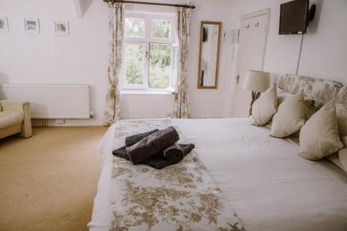 a large white bed in a room with a window at Leygreen Farmhouse B&B in Beaulieu