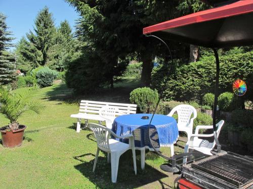 a table and chairs with a table and a grill at Holiday Home Aurora-2 by Interhome in Kurort Steinbach-Hallenberg