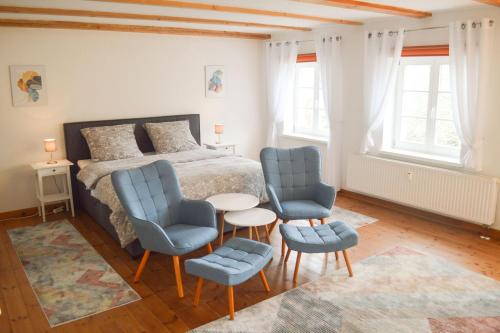 sypialnia z łóżkiem, 2 krzesłami i stołem w obiekcie Gutshaus Neu Necheln w mieście Brüel