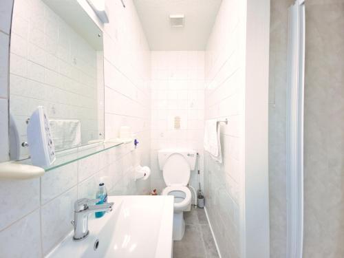 a white bathroom with a toilet and a sink at Apartment 2 - 1 Bedroom Sea Front-Sea Views-Free Parking in Paignton