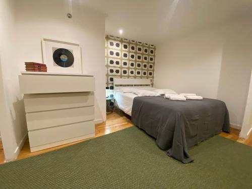 a bedroom with a bed with a dresser and a green rug at Alfama Downtown Apartments in Lisbon