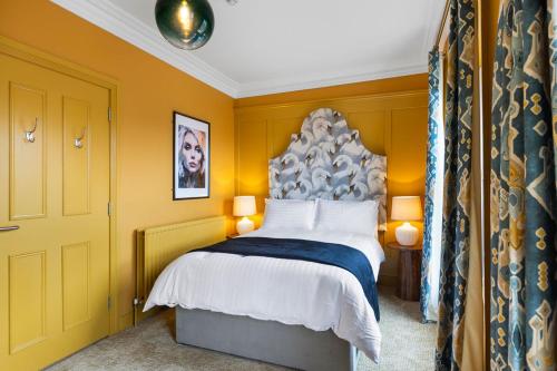 a bedroom with a large bed with yellow walls at Hestia House in Derry Londonderry