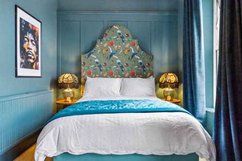 a blue bedroom with a bed with a blue headboard at Hestia House in Derry Londonderry