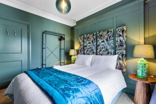 a bedroom with a large bed with a blue wall at Hestia House in Derry Londonderry