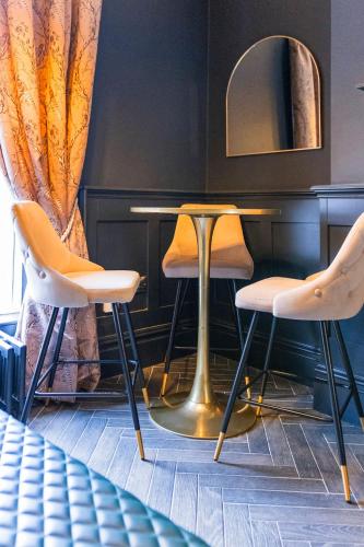 two chairs and a table in a room with a mirror at Hestia House in Derry Londonderry