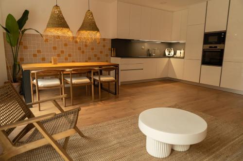 a kitchen and dining room with a table and chairs at Casa Aga- Cozy Seaside Apartment in Ericeira