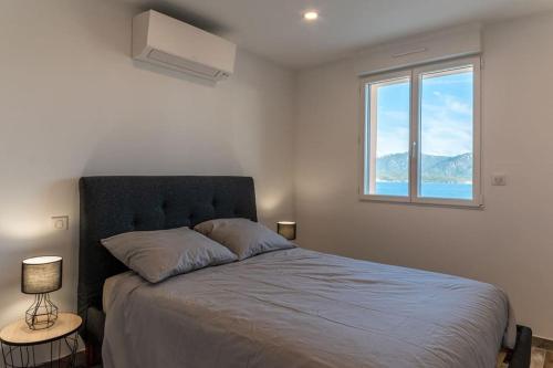Un dormitorio con una cama grande con ventana. en Grand Appartement, Belle vue mer, en Olmeto