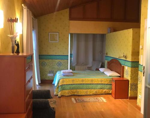 ein Schlafzimmer mit einem Bett in einem Zimmer in der Unterkunft Piscina climatizada todo el año in Valle