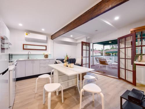 a kitchen with white cabinets and a table and chairs at Serene 3 Bedroom Inner City Retreat Highgate Hill in Brisbane