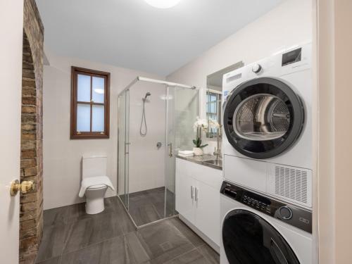 a bathroom with a washer and dryer in a room at Serene 3 Bedroom Inner City Retreat Highgate Hill in Brisbane