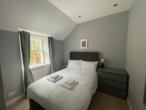 a bedroom with a bed with two towels on it at Carronvale. 3 Bedroom Oban Apartment. in Oban