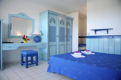 Dormitorio azul con cama azul y escritorio en Résidence Tropicale en Le Moule