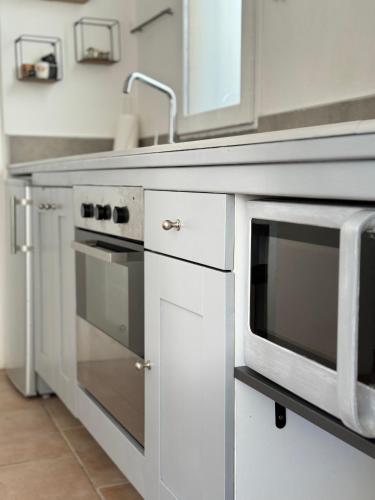 une cuisine avec un évier et un micro-ondes dans l'établissement La vue de la calade, à Peyriac-de-Mer