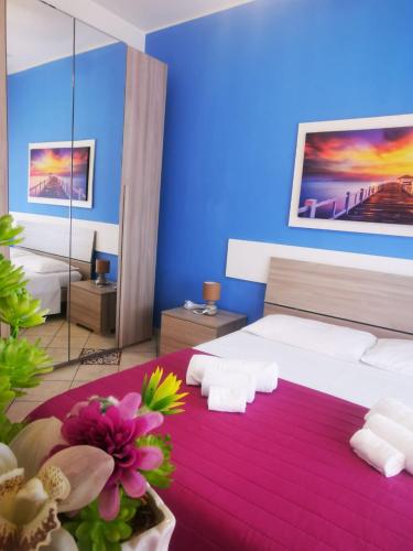Habitación de hotel con 2 camas y pared azul en Appartamento in riva al mare, en Trabia