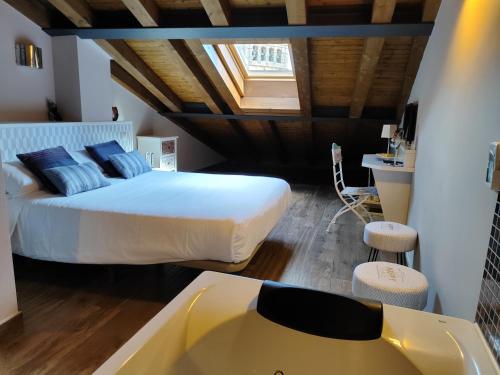 1 dormitorio con cama, bañera y lavamanos en Apartamentos La Alborada Medieval en Ayllón