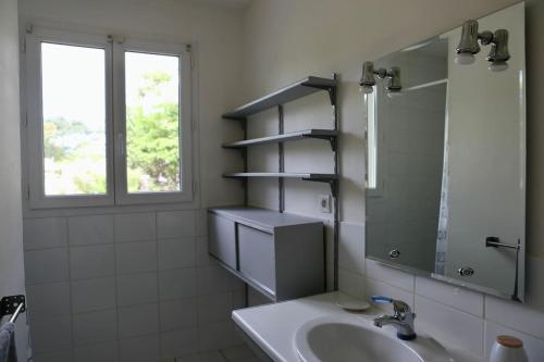 une salle de bain avec un lavabo, un miroir et une fenêtre dans l'établissement Très belle Villa - Plage à pied, à Labenne