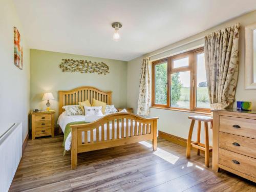 a bedroom with a bed and a dresser and a window at 2 Bed in South Molton ISLVI in South Molton