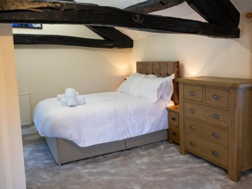 a bedroom with a white bed and a wooden dresser at 3 Bed in Buttermere 82775 in Buttermere