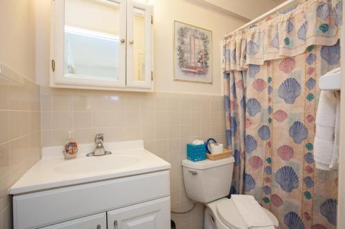 a bathroom with a toilet and a sink and a shower curtain at Venice Villas * Poolside #41A in Venice