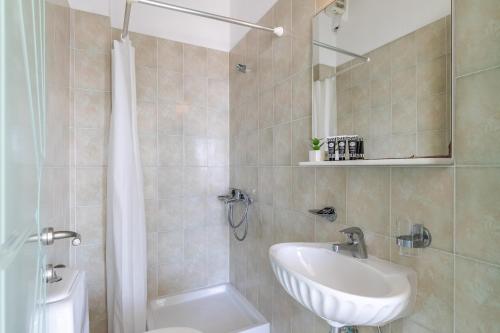 a bathroom with a sink and a toilet and a shower at Belvedere Skopelos in Neo Klima