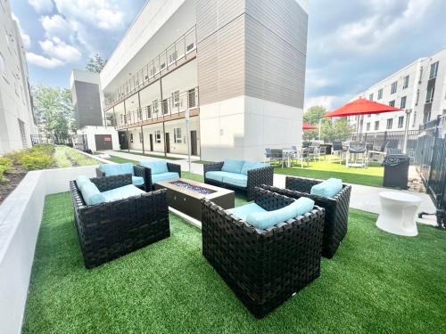 a patio with couches on the grass in front of a building at Hillsborough Street Flat in Raleigh