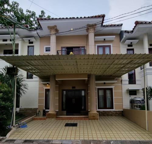 a house with a large umbrella over a patio at Villa Estate 43 New in Batu
