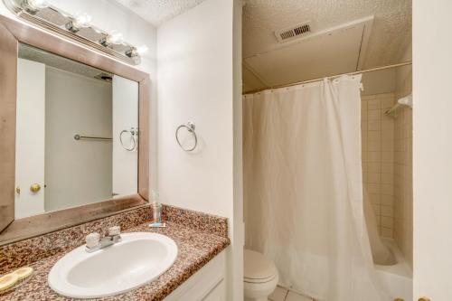 a bathroom with a sink and a toilet and a mirror at Walkable Dallas Condo about 3 Mi to Downtown! in Dallas