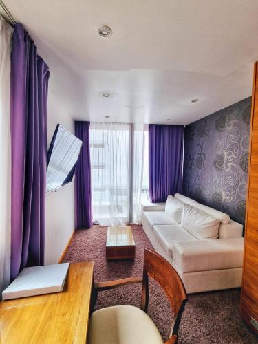 a living room with purple curtains and a couch at Hotel San Antonio in Podstrana