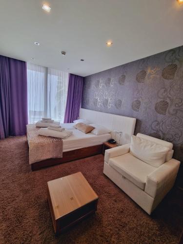 a hotel room with two beds and a couch at Hotel San Antonio in Podstrana
