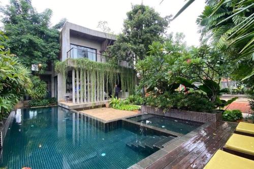a house with a swimming pool in front of a house at Theary Luxury Villa in Siem Reap