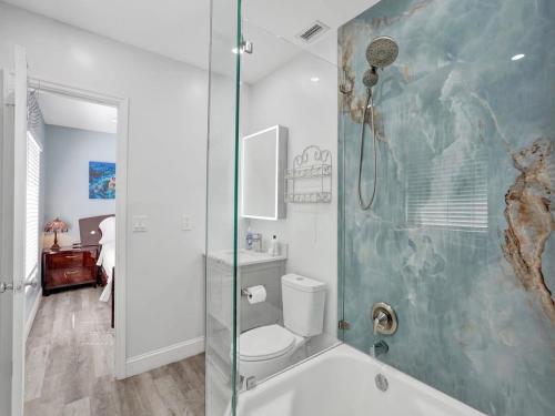 a bathroom with a toilet and a glass shower at 5 Minute Walk to the Beach in Fort Lauderdale