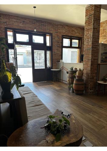 a living room with a table and a brick wall at Hotel Imigrantes in Bento Gonçalves