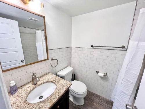 a white bathroom with a sink and a toilet at Crystal City Boutique Flats Free Parking 201 in Arlington