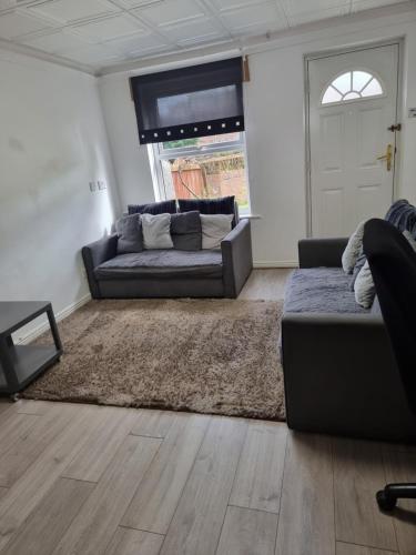 a living room with a couch and a rug at 2 Bedroom Cozy Chambers with free parking in Leeds