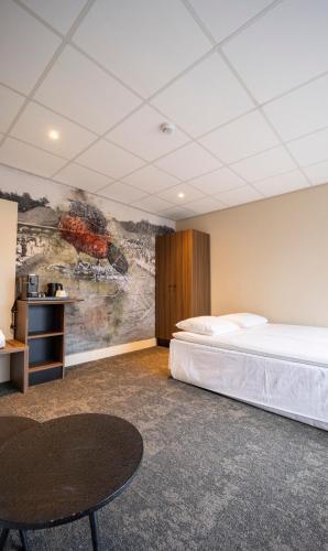 a hotel room with a bed and a painting on the wall at Fletcher Hotel Restaurant Doorwerth - Arnhem in Doorwerth