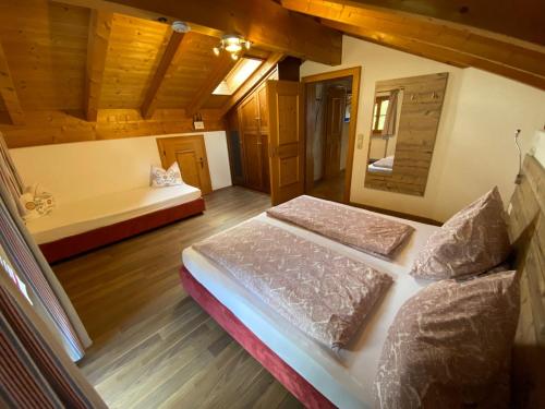 een slaapkamer met 2 bedden in een kamer met houten plafonds bij Haus Hager in Schneizlreuth