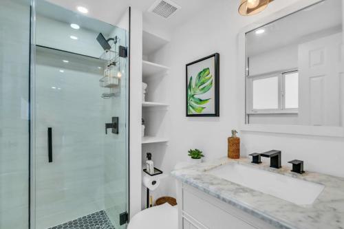 een witte badkamer met een douche en een wastafel bij Zach's Tropical Pool House in Fort Lauderdale