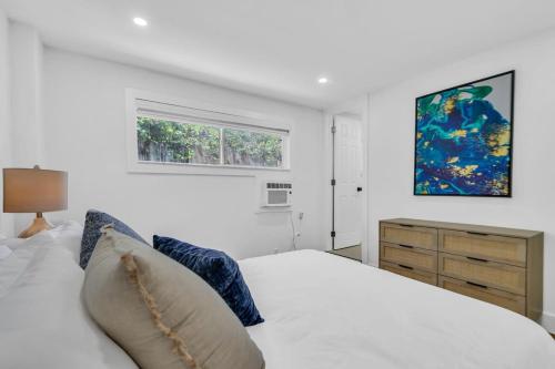 een slaapkamer met een bed en een schilderij aan de muur bij Zach's Tropical Pool House in Fort Lauderdale