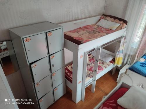 a small bedroom with a bed and a dresser at Hostel "OrmaNOVA" in Almaty